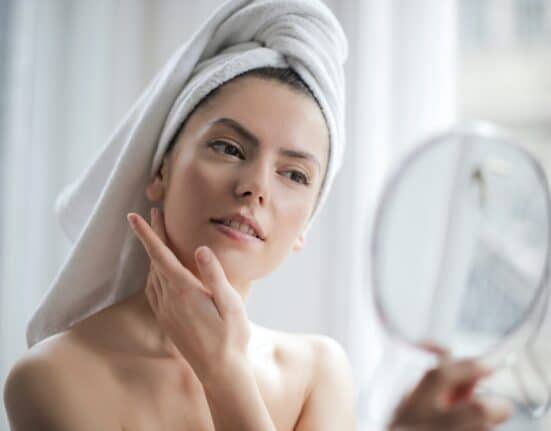 girl watching skin on mirror - skincare routine and skincare treatment