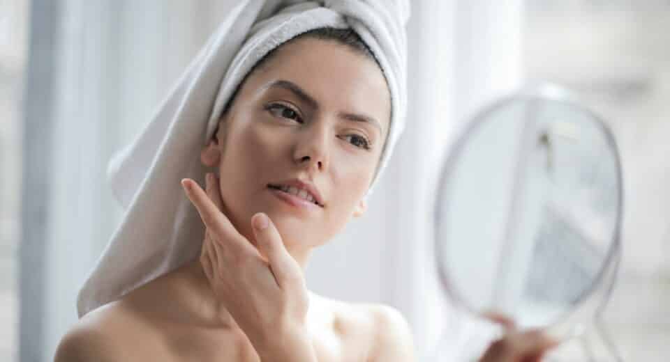 girl watching skin on mirror - skincare routine and skincare treatment